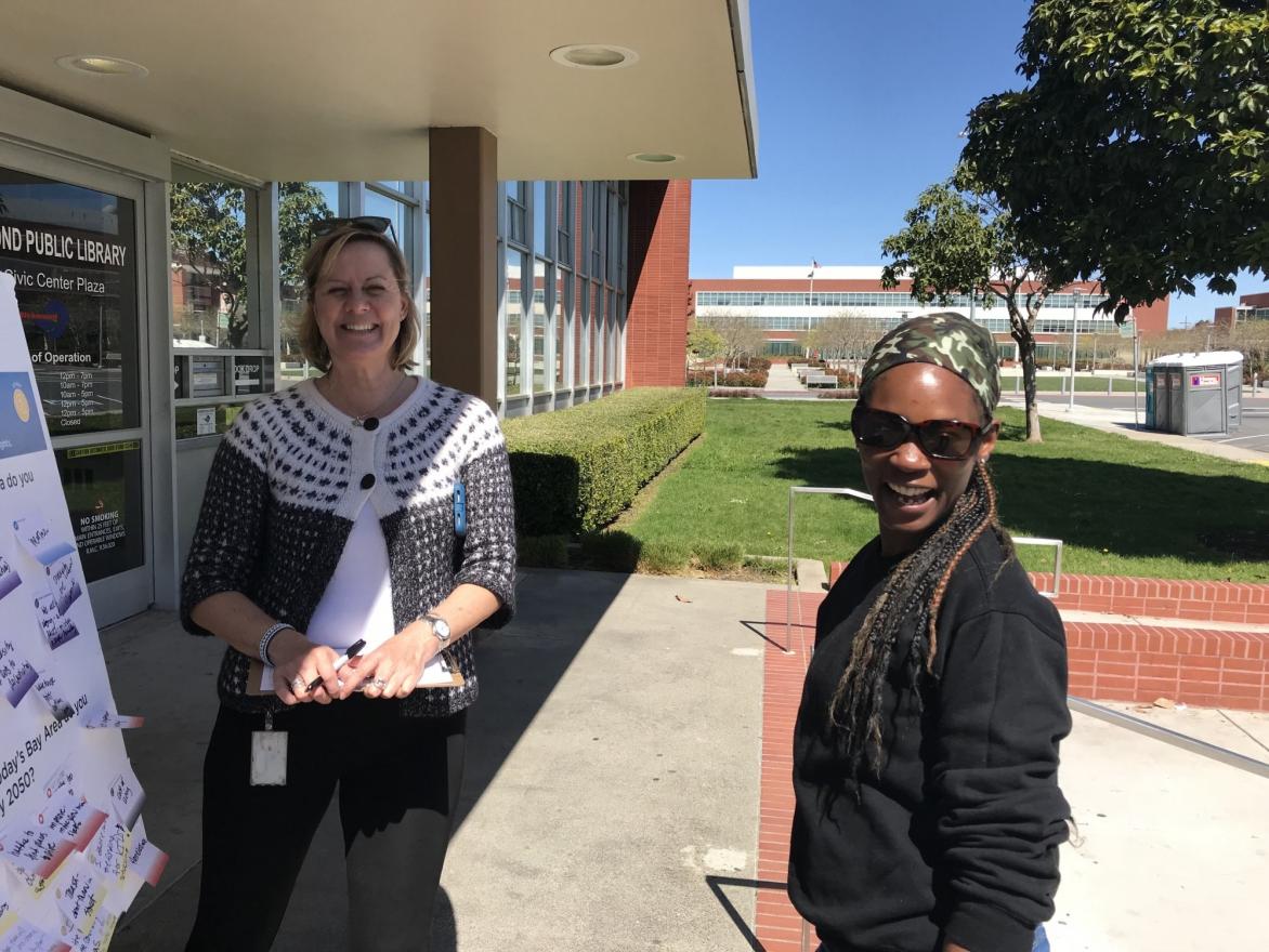 A community member stops to chat with MTC staff in front of the Richmond library.