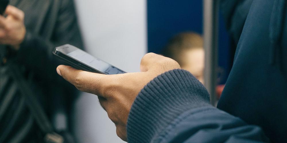 Photo of a hand holding a cell phone by Paul Hanaoka