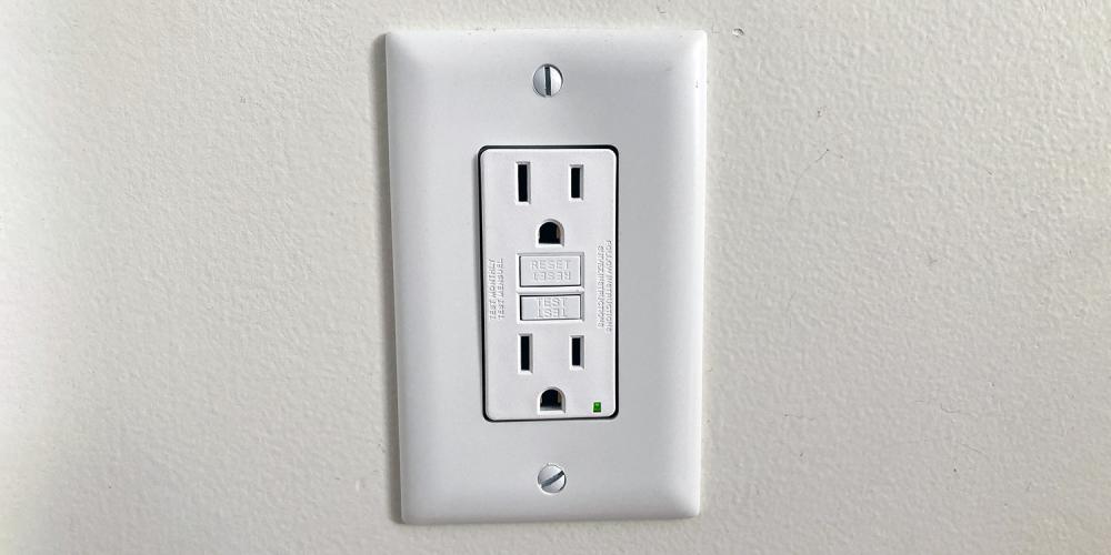 A two-outlet electrical outlet inside a home.