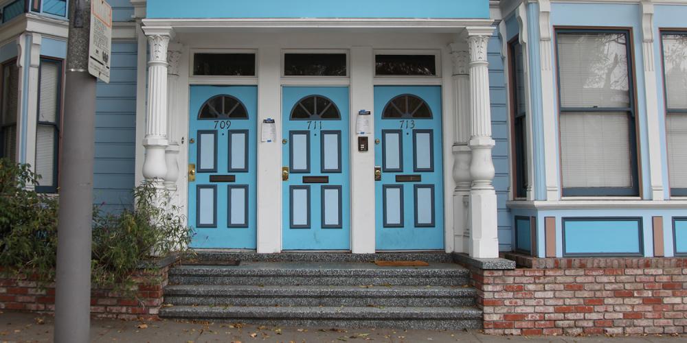 Three colorful doors on an Edwardian style building in San Francisco.