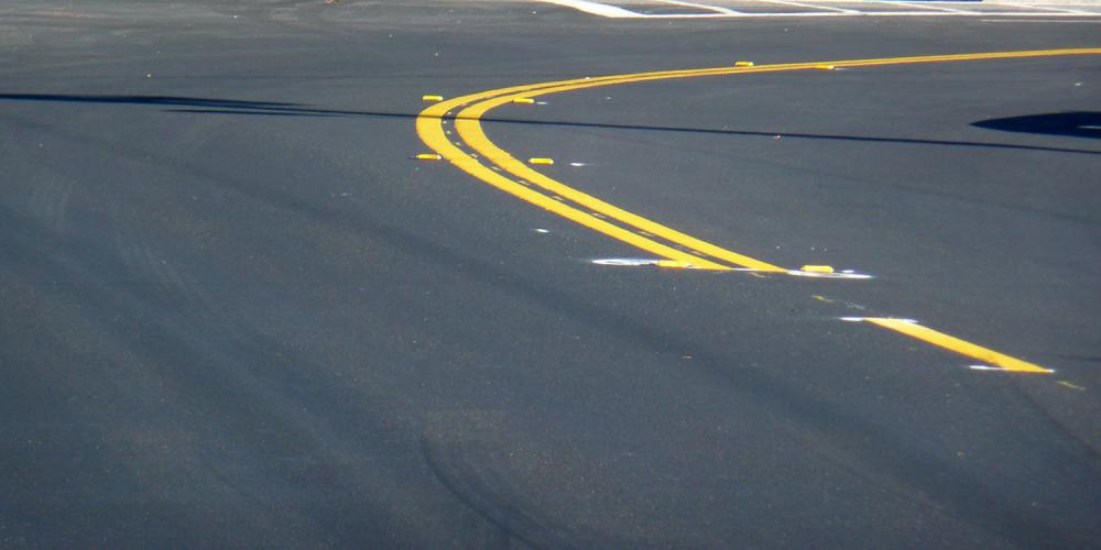 Recently-paved street marked with a double yellow line.