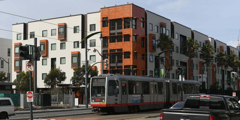 Residential housing in San Francisco's Mission Bay neighborhood, with a Muni light rail train passing on Third Street.