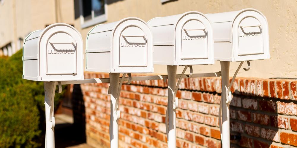 A row of four white mailboxes.