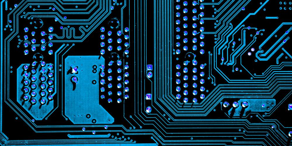Close up of a computer circuit board, image tinted blue.