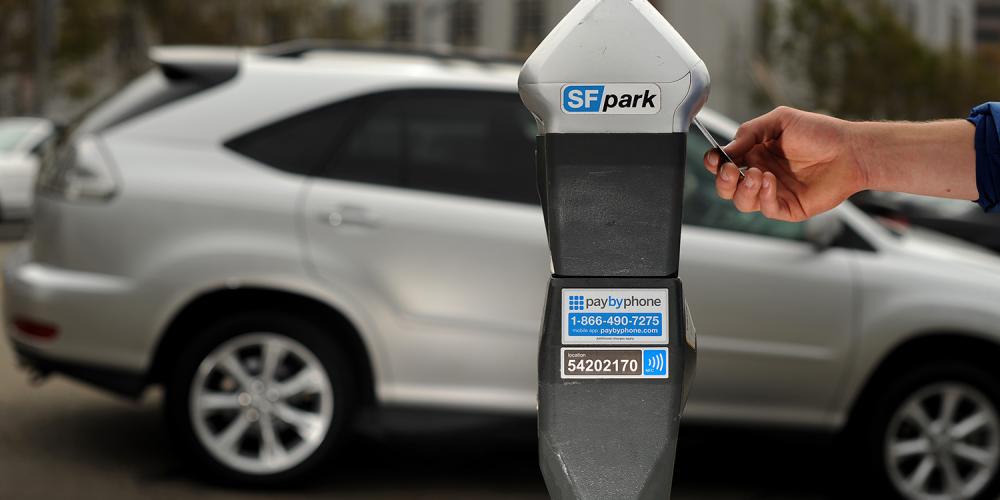 A person pays for parking at a parking meter in San Francisco.