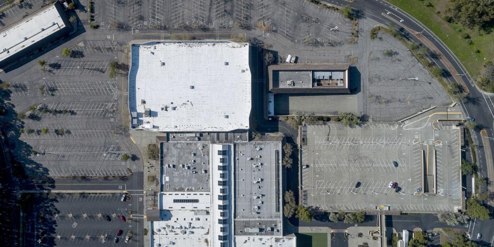 Aerial of a parking lot at an under-used shopping center in Terra Linda, California.