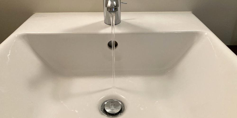 Tap water running into a bathroom sink.