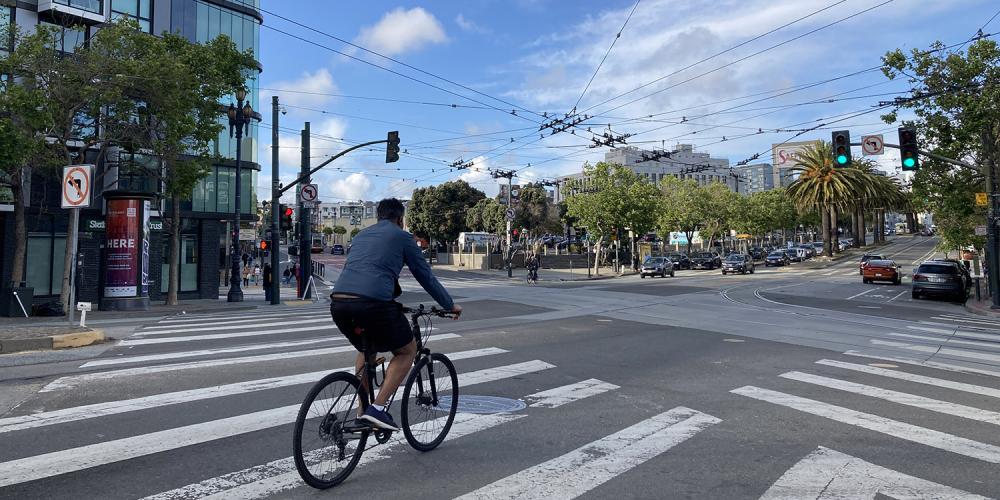 A cyclist crossing the intersection of Market Street and Church Street in San Francisco.