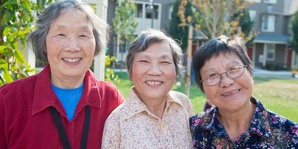 Three smiling Asian senior women.