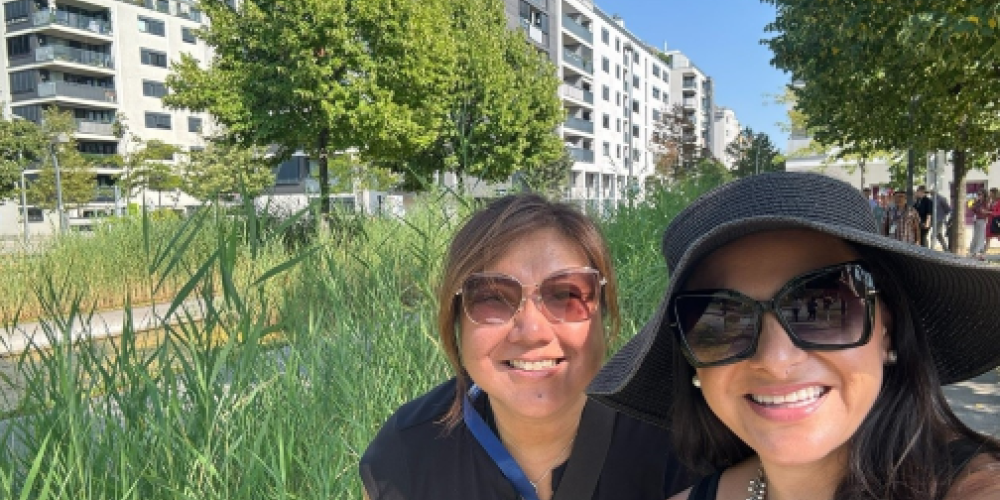 ABAG president Belia Ramos and another woman sit in front of Vienna's public housing