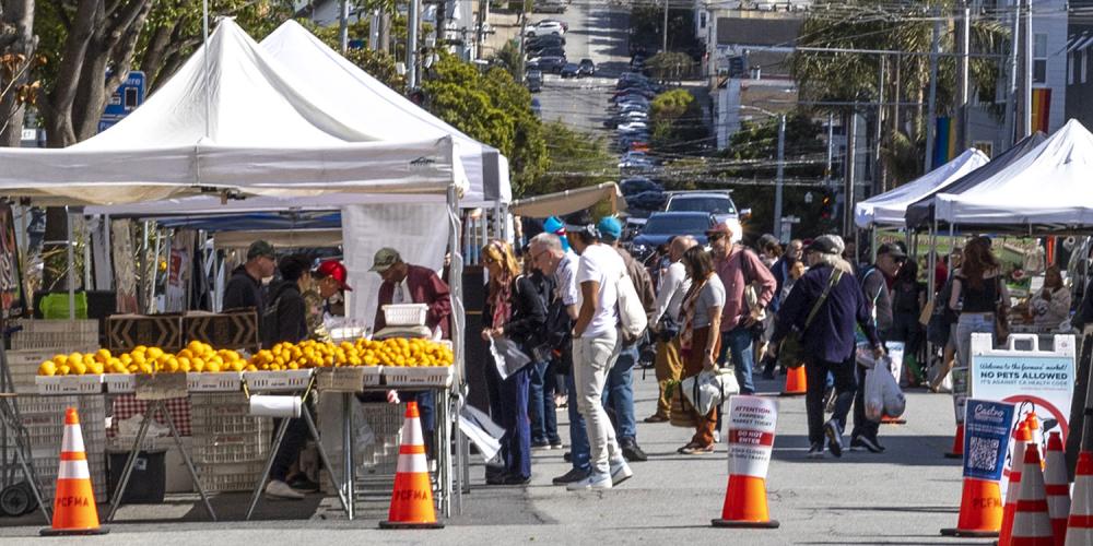 People shopping for produce at the Castro farmers market in San Francisco.