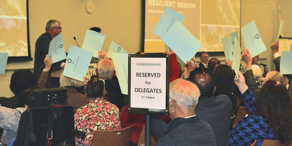 Image of seated people holding up signs during a meeting