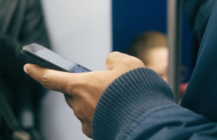 Photo of a hand holding a cell phone by Paul Hanaoka
