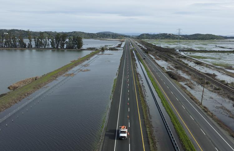 Highway 37 is closed to traffic while CalTrans crews pump flood waters from Novato Creek and the San Francisco Bay off the roadway.