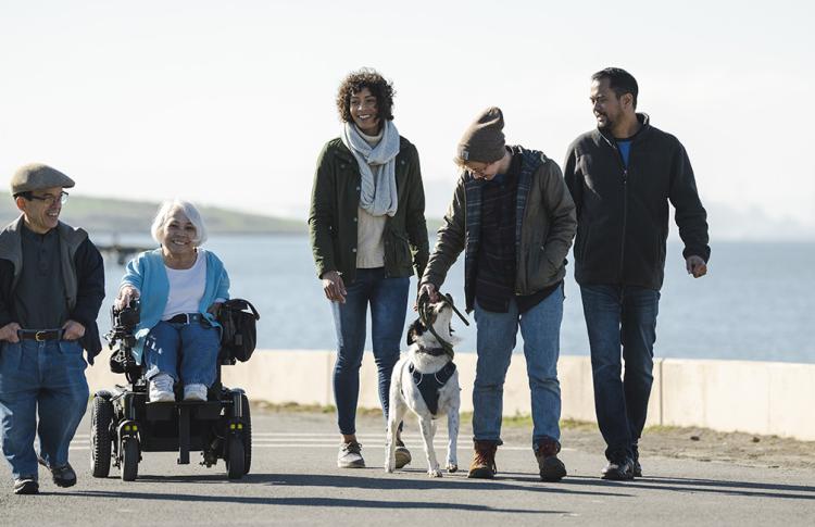 A group of people with diverse body types and abilities stroll along the Bay Trail.