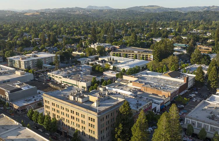 Aerial over apartments in Santa Rosa, with forest in the background.